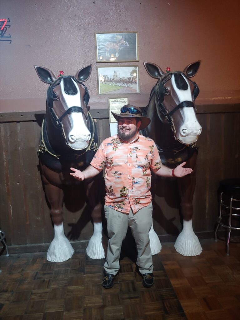 Glen E. Martin in front of two horse statues in a Dallas, TX bar.